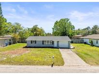 Charming single-story home with a well-maintained lawn and a classic brick-lined driveway at 3210 Acacia St, Lutz, FL 33558