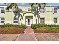 Inviting light green two-story condo building entrance with brick walkway and tropical landscaping at 5101 Coquina Key Se Dr # A, St Petersburg, FL 33705