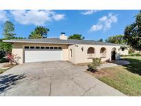 Beige single-story home featuring a two-car garage and arched gated entry at 1006 Mandalay Dr, Brandon, FL 33511