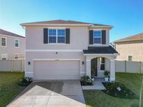 Two-story home featuring a manicured lawn, a two car garage, and welcoming front porch with attractive curb appeal at 10727 Penny Gale Loop, San Antonio, FL 33576