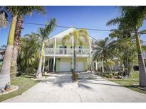 Charming two-story home with white trim, a balcony, a two-car garage, and a beautifully landscaped yard at 112 13Th Ave, Indian Rocks Beach, FL 33785