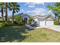 Beautiful single-story home with a three car garage, a well-manicured lawn, and mature landscaping at 12304 Silton Peace Dr, Riverview, FL 33579