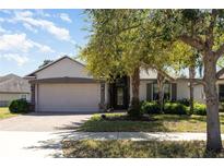 Charming single-story home featuring a brick driveway and lush landscaping around the property at 14205 Stockwell Ln, Ruskin, FL 33573