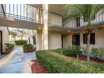 A well-maintained apartment building exterior with landscaped walkway and courtyard view on a sunny day at 2211 Belleair Rd # D12, Clearwater, FL 33764