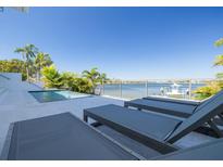 Waterfront pool deck with lounge chairs overlooking a scenic view and serene water at 3418 Overlook Ne Dr, St Petersburg, FL 33703