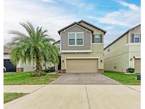 Charming two-story home boasts a well-manicured lawn, paver driveway, and attached two-car garage at 9917 Ivory Dr, Ruskin, FL 33573