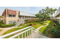 Beautiful condo building with lush green landscaping, offering a serene environment at 10034 64Th N Ave # 14, St Petersburg, FL 33708