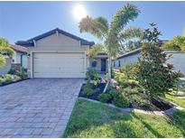 Charming single-story home with a brick driveway and well-manicured landscaping with lush green grass at 120 Moscata Way, Nokomis, FL 34275