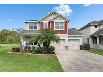Charming two-story home with a well-manicured lawn, brick driveway, and inviting curb appeal at 12328 Streambed Dr, Riverview, FL 33579