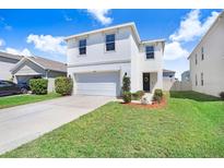 Charming two-story home with a well-manicured lawn and inviting curb appeal, plus an attached two-car garage at 16316 Silent Sands Ln, Odessa, FL 33556