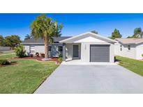 Charming single-story home features a well-manicured lawn, gray exterior paint, and an attached garage at 1766 10Th Sw St, Largo, FL 33778