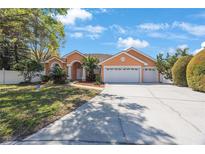 Charming single-story home boasts a three-car garage and manicured landscaping in a suburban neighborhood at 2302 Azalea Dr, Palm Harbor, FL 34683