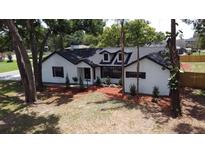 Charming white brick home featuring a well-manicured lawn and mature trees at 2715 Willow Oaks Dr, Valrico, FL 33594