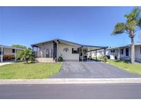 Charming single-story home featuring a covered porch, extended driveway and lush landscaping at 3051 Shady Creek Dr, Wesley Chapel, FL 33543