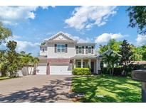 Beautiful two-story home with a well-manicured lawn, brick accents, and a three-car garage at 4117 W Platt St, Tampa, FL 33609