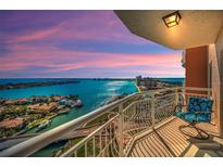 Enjoy panoramic water views from this condo's private balcony, complete with comfortable seating and scenic pink skies at 4900 Brittany S Dr # 1606, St Petersburg, FL 33715