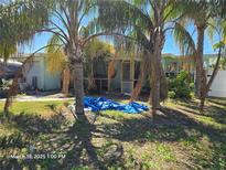 Lush tropical landscaping frames the exterior of this charming home, offering shade and privacy at 593 Trade Winds Dr, Dunedin, FL 34698