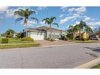 Beautiful home with a lush landscaped lawn and a brick driveway at 689 Chipper Dr, Sun City Center, FL 33573