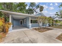 Charming blue home featuring a covered parking area and well-manicured landscaping at 1039 23Rd St, Sarasota, FL 34234