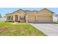 Charming, single-story home featuring stucco siding, a manicured lawn, and a two-car garage at 12442 Curry Dr, Spring Hill, FL 34609