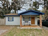 Charming single story home featuring a cozy porch with rocking chairs and blue accents at 1731 W Perio St, Tampa, FL 33612