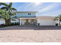 Charming two-story home with a brick driveway and lush tropical landscaping at 200 Driftwood W Dr, Palm Harbor, FL 34683