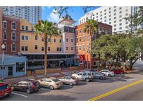 Charming street view of mixed-use building with colorful facades and street parking in a bustling urban setting at 215 Central Ave # 4H, St Petersburg, FL 33701