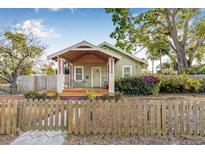 Charming home featuring a well-manicured lawn, delightful front porch, and a quaint wooden fence at 3000 2Nd N Ave, St Petersburg, FL 33713