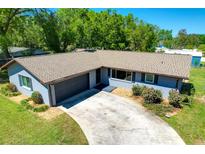 Charming single-story home with a well-maintained lawn and a driveway leading to an attached garage at 37451 Hickory Hill Ln, Dade City, FL 33525