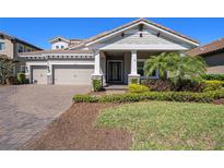 Beautiful single-Gathering home with three-car garage, landscaped front yard, and covered entryway with brick accents at 4782 Night Star Trl, Odessa, FL 33556