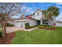 Charming two-story home features a two-car garage and a well-manicured lawn and landscaping at 8141 Carlton Ridge Dr, Land O Lakes, FL 34638