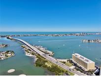 Stunning aerial view showcasing the waterfront property, bridge and expansive ocean views at 100 Bluff View Dr # 117C, Belleair Bluffs, FL 33770