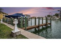 A private boat dock offers waterfront access for residents, with a purple sunset sky at 11525 Gulf Blvd # 401, Treasure Island, FL 33706