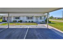 Charming single-story home with a covered parking area and well-maintained landscaping at 124 Gloucester Blvd # 355J, Sun City Center, FL 33573