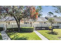 Charming home featuring a well-maintained lawn, mature tree, and a cozy, inviting entrance at 1333 Shady Pine Way # B, Tarpon Springs, FL 34688
