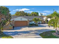 Charming home exterior showcasing stone accents, paver driveway, lush landscaping, and attached two-car garage at 22 Oak Ave, Palm Harbor, FL 34684