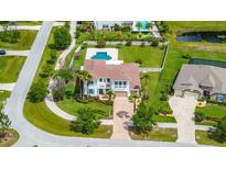 Expansive aerial view of a two-story home with a private pool, manicured lawn, and mature trees at 3226 Cordoba Ranch Blvd, Lutz, FL 33559