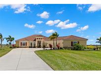 Inviting single-story home featuring a well-manicured lawn, tiled roof, and a spacious driveway at 3487 Recurve Cir, Sarasota, FL 34240