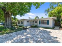 Charming single-story home featuring a well-manicured front yard and a beautiful brick driveway at 3818 W San Miguel St, Tampa, FL 33629