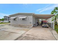 Charming manufactured home featuring a spacious carport with room for parking and a boat at 110 E Saint Lucia Loop, Apollo Beach, FL 33572