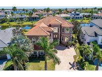 Stunning front exterior featuring a tile roof, manicured lawn, and mature landscaping at 1408 Alhambra Dr, Apollo Beach, FL 33572