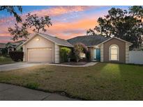 Charming single-story home showcasing a well-maintained lawn and a stylish blue front door at 2329 Towering Oaks Cir, Seffner, FL 33584