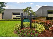 Well-maintained condo complex featuring mature landscaping and an inviting entrance sign at 36750 Us 19 N # 08102, Palm Harbor, FL 34684