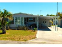 Charming single-story home with a covered carport and well-maintained landscaping at 5546 Benton St, Zephyrhills, FL 33542