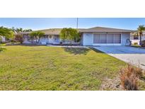 Charming single-story home with a well-manicured lawn and mature landscaping at 672 Allegheny Dr, Sun City Center, FL 33573