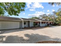 Home exterior view showing a two-car garage and a curved driveway at 705 S West Shore Blvd, Tampa, FL 33609