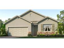 Charming single-story home showcasing neutral siding, stone accents, and a well-maintained landscaped yard at 7174 Beaverhead Ln, Land O Lakes, FL 34638