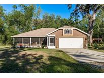 Charming single-story home with a well-maintained lawn, screened in porch and an attached two car garage at 7182 Griffin Rd, Brooksville, FL 34601