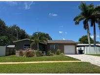 Charming single-story home with a well-maintained lawn, mature trees, and a driveway leading to a one-car garage at 1836 Bayou Grande Ne Blvd, St Petersburg, FL 33703