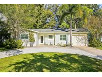 Charming single-story home featuring a lush landscaped yard, ample parking, and a welcoming front entrance at 1908 Sutherland W Dr, Palm Harbor, FL 34683